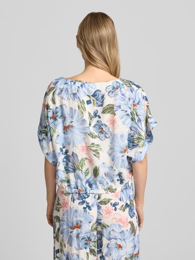 Frauenmodel trägt Bluse aus Viskose-Mix mit U-Boot-Ausschnitt von Oui, florales Muster, Gerader-Schnitt, Fledermausärmel, Elastikbündchen, Leinen-Viskose-Anteil, Rückenlänge 48 cm bei Größe 36, Ganzkörperansicht Rückansicht.
