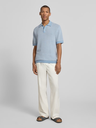 Męski model nosi koszulkę polo Regular Fit Poloshirt in Strick-Optik model 'Kingsley' od Jack & Jones Premium, bawełna, imitacja dzianiny, z krótkim rękawem, kołnierzyk polo, elastyczne wykończenia, długość tyłu w rozmiarze M: 77 cm, jasnoniebieski i jasny beż, gładka faktura, pełna sylwetka z przodu.