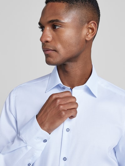 Männermodel trägt Slim Fit Businesshemd aus Baumwoll-Mix mit Kentkragen von OLYMP Level Five, hellblau, Knopfleiste, Nahaufnahme Oberkörper.