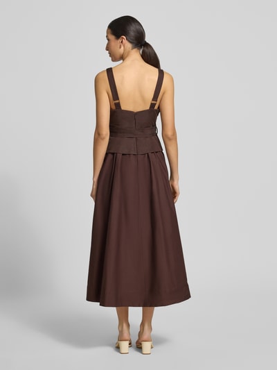 Frauenmodel trägt Cocktailkleid aus Leinen-Viskose-Mix Modell 'Celina' von Forever New in Braun, A-Linie, 2-in-1-Look, Ganzkörperansicht Rückansicht. Rückenlänge bei Größe 36: 31 cm, Brustweite bei Größe 36: 41 cm.