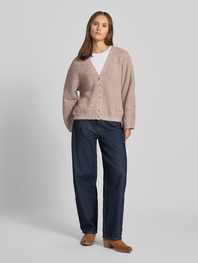 Frauenmodel trägt Strickjacke mit V-Ausschnitt Modell 'RENE' von Topshop, relaxed Fit, Strukturmuster, Ganzkörperansicht von vorne.