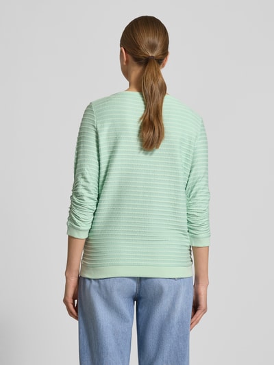 Vrouwenmodel draagt Shaped Fit Sweatshirt aus Baumwoll-Viskose-Mix van Tom Tailor Denim, effen lichtgroen, jacquardstructuur, geribde boorden, gestreept, ronde hals, lange mouw, Ganzkörperansicht achteraan.