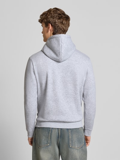Männermodel trägt Hoodie mit Kapuze Modell 'BRADLEY' von Jack & Jones in Hellgrau, Material-Mix, lockerer Schnitt, Ganzkörperansicht Rückansicht.