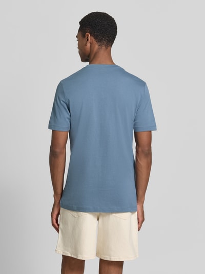 Męski model nosi Regular Fit T-Shirt aus reiner Baumwolle von s.Oliver RED LABEL, efekt: jednolity kolor, krój regular fit, nadruk z logo, okrągły dekolt, krótki rękaw, wykończenie materiału: dżersej, materiał: czysta bawełna, całkowity widok z tyłu.