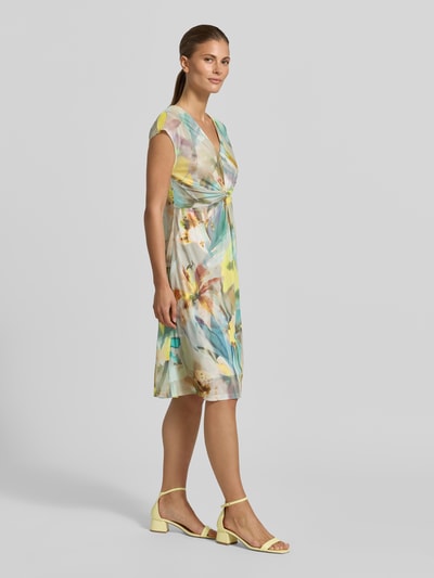 Frauenmodel trägt Minikleid mit V-Ausschnitt und Knotendetail von Betty Barclay im Allover-Look, Material-Mix mit Stretch-Anteil, Taillierter Schnitt, Ganzkörperansicht von vorne.