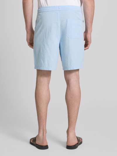 Männermodel trägt Regular Fit Shorts aus reiner Baumwolle Modell 'STUART' von SELECTED HOMME, Optik: Unifarben, Materialverarbeitung: Seersucker, Passform: Regular-Fit, Bundabschluss: elastisch, seitliche Eingrifftaschen, Gesäßtaschen, Ganzkörperansicht Rückansicht.