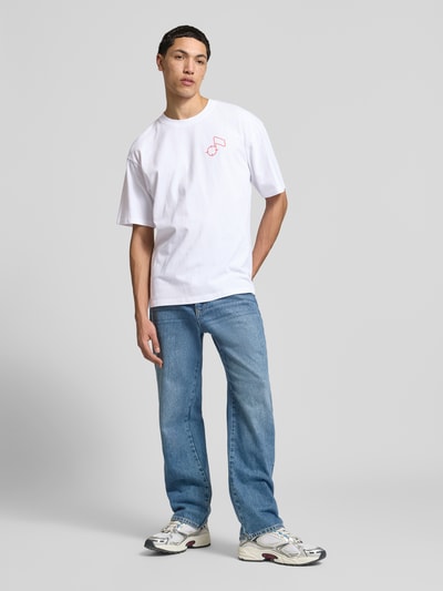 Męski model nosi t-shirt z bawełny model 'CHARMER' od Edwin, prosty krój, okrągły dekolt, długość tyłu w rozmiarze M: 70 cm, całkowity widok z przodu