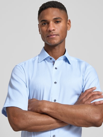 Männermodel trägt Regular Fit Business-Hemd mit Kentkragen von OLYMP, hellblau, reine Baumwolle, unifarben, Nahaufnahme Oberkörper.