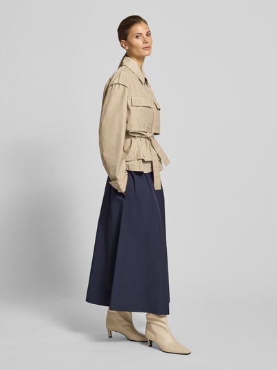 Vrouwenmodel draagt Midirock met elastische tailleband van Christian Berg Woman Selection, A-lijn, katoenmix, plooien, zijaanzicht.