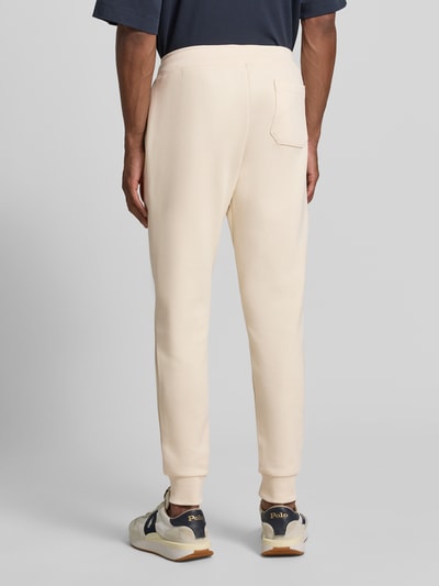 Männermodel trägt Regular Fit Sweathose aus Baumwoll-Mix von Polo Ralph Lauren in Creme, glatte Struktur, Ganzkörperansicht Rückansicht, Herren