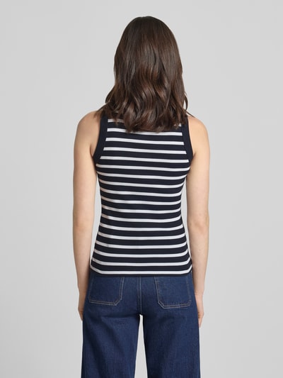 Frauenmodel trägt Tanktop mit Rippenstruktur Modell 'OLINA' von Drykorn in marineblau-weißen Streifen, Reine Baumwolle, eng anliegender Schnitt, Rückenlänge bei Größe S: 55 cm, Ganzkörperansicht Rückansicht.