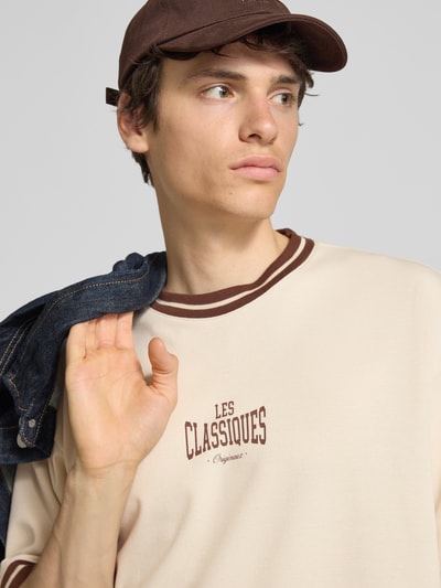 Männermodel trägt Boxy Fit T-Shirt aus reiner Baumwolle Modell 'LES' von Only & Sons, Optik: Unifarben, Label-Print, Nahaufnahme Oberkörper.
