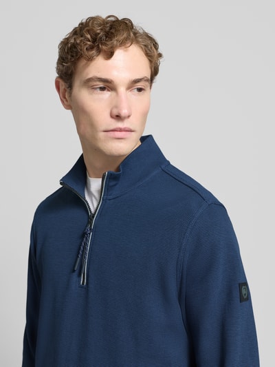 Męskimodel nosi Sweatshirt mit Stehkragen und Reißverschluss od Lerros, mieszanka bawełny, krój regular fit, fakturowany wzór, stójka, zamek błyskawiczny, długość tyłu 71 cm, długość rękawów 59 cm, kolor granatowy, faktura delikatnie widoczna, nahaufnahme górnej części ciała.