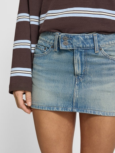 Mädchen trägt Jeansrock im Used-Look mit Eingrifftaschen von Levi's®, bawełna, prosty krój, minispódnica, Szerokość w rozmiarze 27: 40 cm, długość całkowita w rozmiarze 27: 30 cm, zdjęcie: zbliżenie na dolną część ciała.