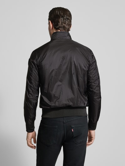 Männermodel trägt schwarze Jacke mit Reißverschlusstaschen Modell 'Brahms' von Blauer Usa, Stehkragen, Regular Fit, Ganzkörperansicht Rückansicht.