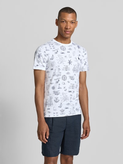 Mężczyzna nosi męski t-shirt Slim Fit T-Shirt aus reiner Baumwolle von Polo Ralph Lauren w białym kolorze z granatowym nadrukiem, Ganzkörperansicht von vorne.