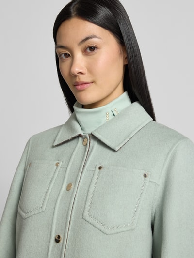 Vrouwenmodel draagt Wendejacke met knoopsluiting en borstzakken van Marc Cain, puur katoen, regular fit, platte kraag, detailopname bovenlichaam.