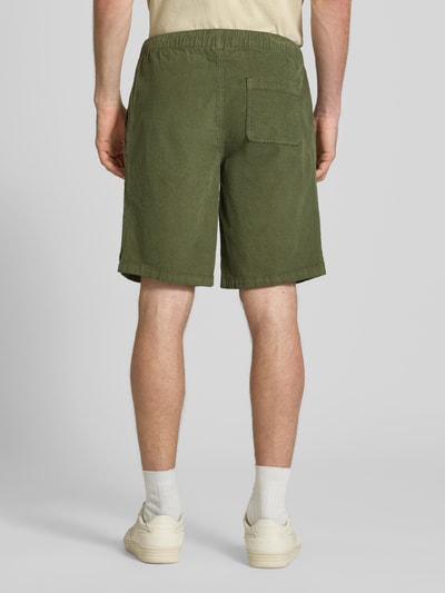 Männermodel trägt Regular Fit Shorts mit Tunnelzug Modell 'Joey' von Redefined Rebel aus grünem Cord, Baumwoll-Elasthan-Mix, Ganzkörperansicht Rückansicht. Herren Shorts, Bundweite 39 cm, Innenbeinlänge 25 cm, Größe M.