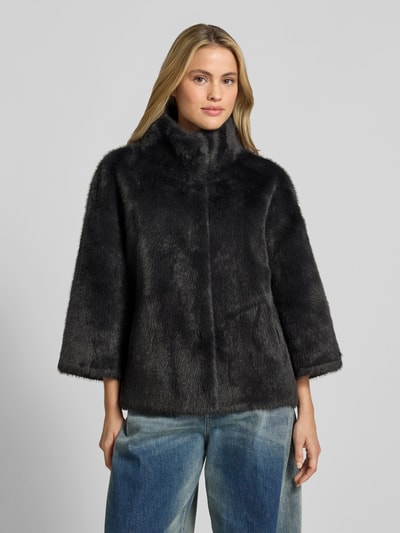 Kobiece model prezentuje Wendejacke aus Kunstfell od Juvia, czarny sztuczne futro, prosty krój, wpuszczane kieszenie, stójka, funkcja dwustronna, długość tyłu w rozmiarze S: 63 cm, szerokość w rozmiarze S: 54 cm, długość rękawów w rozmiarze S: 47 cm, widok całej sylwetki z przodu.
