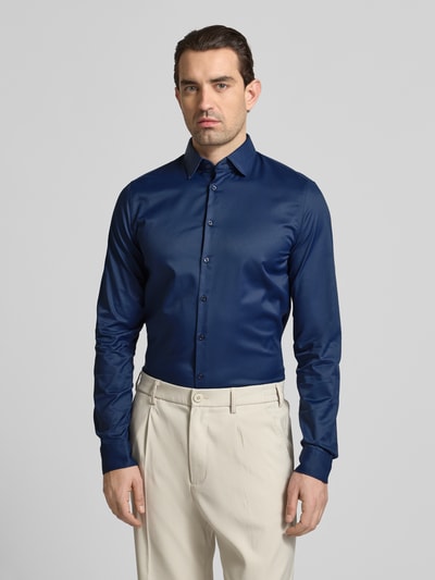 Mężczyznamodel nosi Slim Fit Business-Hemd mit Kentkragen und extra langem Ärmel von Jake*s, ciemnoniebieska koszula z materiału z domieszką stretchu, krój slim fit, długi rękaw, kent, długość tyłu w rozmiarze 39/40: 80 cm, szerokość w rozmiarze 39/40: 44 cm, długość rękawa w rozmiarze 39/40: 71 cm, widok całej sylwetki z przodu.