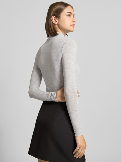 Frauenmodel trägt Regular Fit Langarmshirt mit Viskose-Anteil Modell 'GLAMOUR' von ONLY, hellgrau, kombiniert mit schwarzem Rock, Ganzkörperansicht Rückansicht, Damen Langarmshirt von ONLY.
