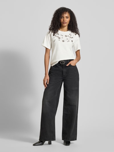 Frauenmodel trägt Slim Fit T-Shirt aus reiner Baumwolle Modell 'DAGILE' von Weekend Max Mara, Optik: unifarben, Logo-Print, Pailletten, Rundhals, Kurzarm, gerade Abschlüsse, Weiß mit schwarzer Applikation, glatte Textur, Ganzkörperansicht von vorne.
