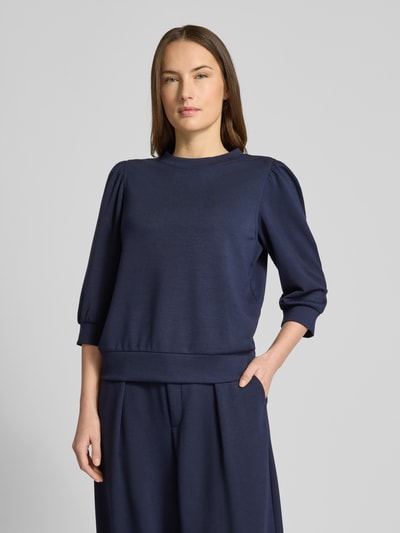 Modelka nosi Loose Fit Sweatshirt mit 3/4-Arm von Rich & Royal, granatowy kolor, balonowe rękawy, stójka, mieszanka modalu, ujęcie całej sylwetki z przodu.