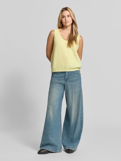 Frauenmodel trägt Relaxed Fit Pullunder aus Alpaka-Leinen-Mix Modell 'VITOW' von American Vintage in Strick-Optik und Pastellgelb, kombiniert mit weitem Jeans, elastisch, ärmellos, Rundhalsausschnitt, Rückenlänge Größe XS/S 45 cm, Ganzkörperansicht von vorne.