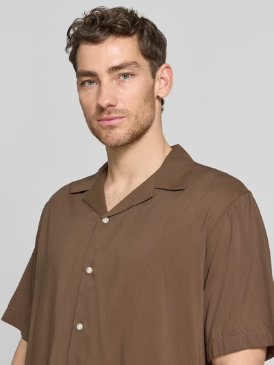 Männermodel trägt Relaxed Fit Freizeithemd aus Bio-Baumwoll-Modal-Mix Modell 'RELAXAIR' von SELECTED HOMME, Optik: Unifarben, Reverskragen, durchgehende Knopfleiste, Kurzarm, Ganzkörperansicht von vorne.