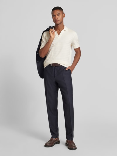 Männermodel trägt Poloshirt mit gerippten Abschlüssen Modell 'Cleison' von JOOP! Collection, reine Baumwolle, Regular-Fit, Polokragen, V-Ausschnitt, dunkle Hose, Ganzkörperansicht von vorne.