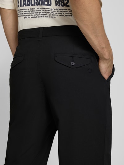 Mężczyznamodel nosi Regular Fit Bundfaltenhose mit Gesäßtaschen von REVIEW, czarne spodnie z zakładkami w pasie, Mieszanka materiałów z dodatkiem wiskozy, szerokość w rozmiarze M 46 cm, długość wewnętrzna nogawki w rozmiarze M 78 cm, detailaufnahme tylu.