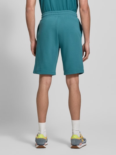 Männermodel trägt Shorts mit Label-Stitching von PUMA PERFORMANCE in Blau, elastischer Bund, Baumwoll-Mix, Ganzkörperansicht Rückansicht.