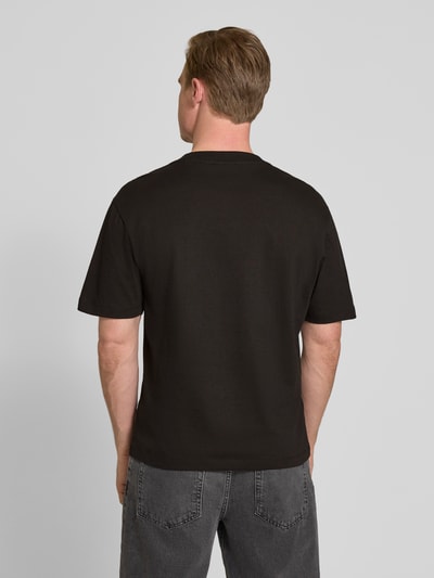 Männermodel trägt Regular Fit T-Shirt aus reiner Baumwolle Modell 'DARRO' von HUGO, Optik: Unifarben, Ganzkörperansicht Rückansicht.