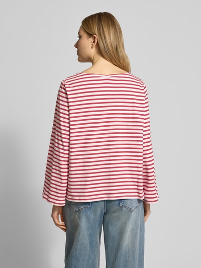 Vrouwenmodel draagt Loose Fit Langarmshirt uit zuivere katoen van Soyaconcept met boothals en lange mouwen, ruglengte 56 cm, volledig gestreept in rood en wit, losse pasvorm; volledige lichaamsaanzicht achteraan.