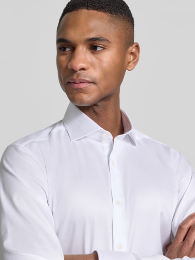 Männermodel trägt slim fit 'Slim Fit Business-Hemd in unifarbenem Design mit Kentkragen' von OLYMP Level Five aus puur katoen, effen kleuren, kentkraag en knoopsluiting, context heren zakelijk hemd, ruglengte 81 cm, schouderbreedte 44 cm, mouwlengte 68 cm, nahaufnahme oberkörper.