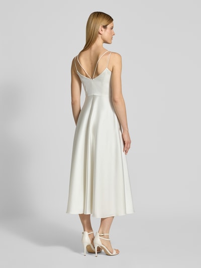 Frauenmodel trägt Brautkleid aus Satin mit V-Ausschnitt von Jake*s Cocktail, A-Linie, Midikleid, Spaghettiträger, Rückseitiger Reißverschluss, Rückenlänge 104 cm, Brustweite 35 cm, cremefarben, leicht glänzende Oberfläche, fließende Form, Ganzkörperansicht Rückansicht.
