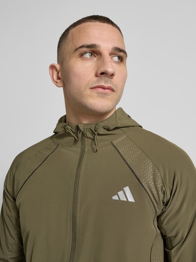 Männermodel trägt Regular Fit Trainingsjacke mit Kapuze von adidas Training in Unifarben, Label-Print, CLIMACOOL Technologie, Nahaufnahme Oberkörper.