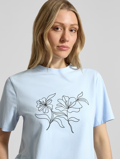Frauenmodel trägt T-Shirt mit Stitching Modell 'NORA' von Vila, hellblau, Blumen-Stitching, Baumwoll-Elasthan-Mix, Regular-Fit, Rundhalsausschnitt, Nahaufnahme Oberkörper.