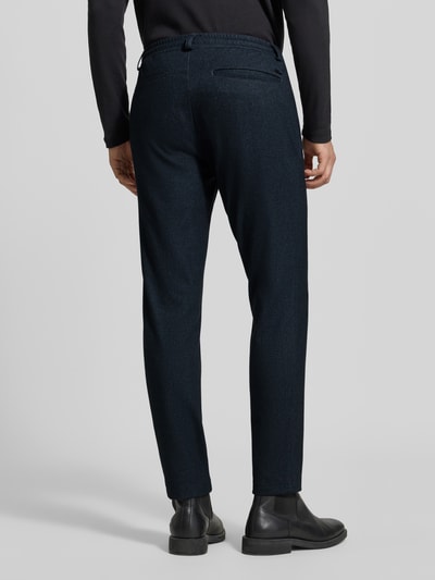Männermodel trägt Tapered Fit Jogpants mit Viskose-Anteil Modell 'Phil KBE' von Brax, dunkelblau, Strukturstoff, Ganzkörperansicht Rückansicht, Herren Schmale Hose.