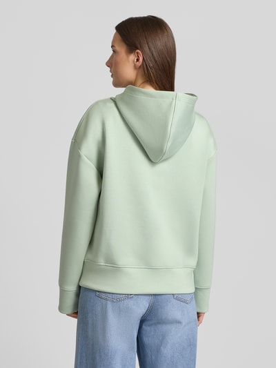 Vrouwenmodel draagt lichtgroene Regular Fit Hoodie uit viscose-mix met steekzakken van Fynch-Hatton, elastische boorden, totaal achteraanzicht.