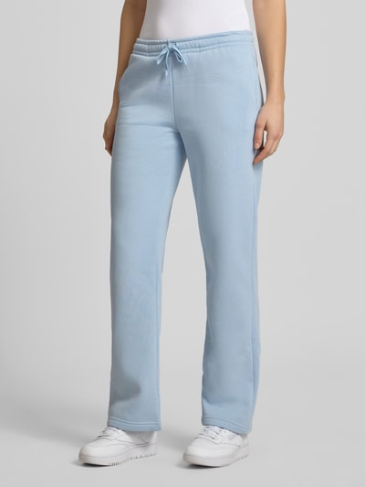 Frauenmodel trägt hellblaue Sweatpants mit elastischem Bund Modell 'Iconic' von Gina Tricot im Baumwoll-Mix, Relaxed Fit, Nahaufnahme Unterkörper.