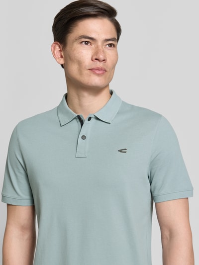 Männermodel trägt Regular Fit Poloshirt in unifarbenem Design van camel active, katoen-elastaan mix, knoopsluiting, logo, Nahaufnahme Oberkörper.