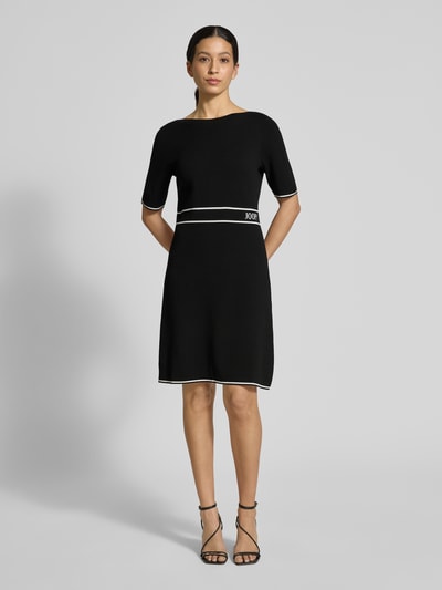 Frauenmodel trägt Regular Fit Kleid aus Viskose-Mix Modell 'Kirla' von JOOP! in Schwarz mit Strick-Optik, Halbarm-Design, Logo-Stitching, Ganzkörperansicht von vorne. Rückenlänge 91 cm, Brustweite 45 cm, Ärmellänge 30 cm.