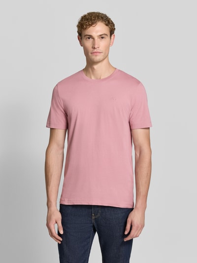 Männermodel trägt Regular Fit T-Shirt aus reiner Baumwolle von Tom Tailor in Rosa, kombiniert mit Jeans, Ganzkörperansicht von vorne, Herren T-Shirt von Tom Tailor.