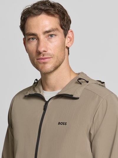 Männermodel trägt Regular Fit Trainingsjacke mit Label-Print Modell 'OW_Airynix JT HD 2' von BOSS für BOSS Green, Nahaufnahme Oberkörper.