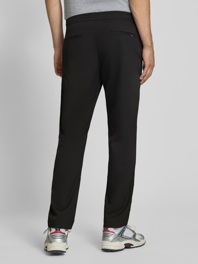 Männermodel trägt Relaxed Fit Hose mit elastischem Bund Modell 'TOBY' von JACK & JONES, Schwarz, Gesäßtaschen, Ganzkörperansicht Rückansicht.