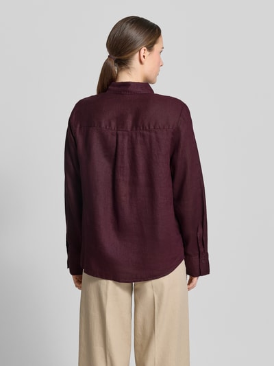 Frauenmodel trägt Leinenbluse mit Brusttasche Modell 'LINO' von Mango in Dunkelrot, Loose-Fit, Sportmanschetten, Rückenlänge 67 cm, Ganzkörperansicht Rückansicht.