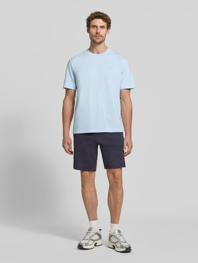 Męski model trägt Regular Fit T-Shirt aus reiner Baumwolle von Lacoste w jasnoniebieskim kolorze, gładka faktura, Ganzkörperansicht von vorne. Męski t-shirt Lacoste