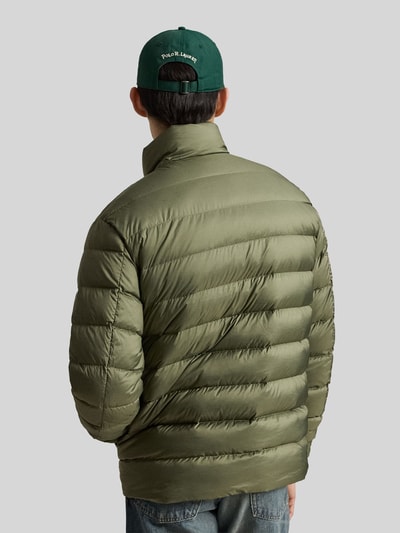 Męski model nosi Regular Fit Steppjacke mit Logo-Stitching od Polo Ralph Lauren, kurtka pikowana, jednokolorowy, wpuszczane kieszenie, zamek błyskawiczny, stójka, długi rękaw, aplikacja z wyhaftowanym logo, widok całej sylwetki od tyłu.