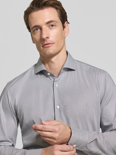 Männermodel trägt Slim Fit Businesshemd aus reiner Baumwolle Modell 'HANK' von BOSS in hellgrau, feine Streifen, Nahaufnahme Oberkörper. Herren Businesshemd von BOSS.